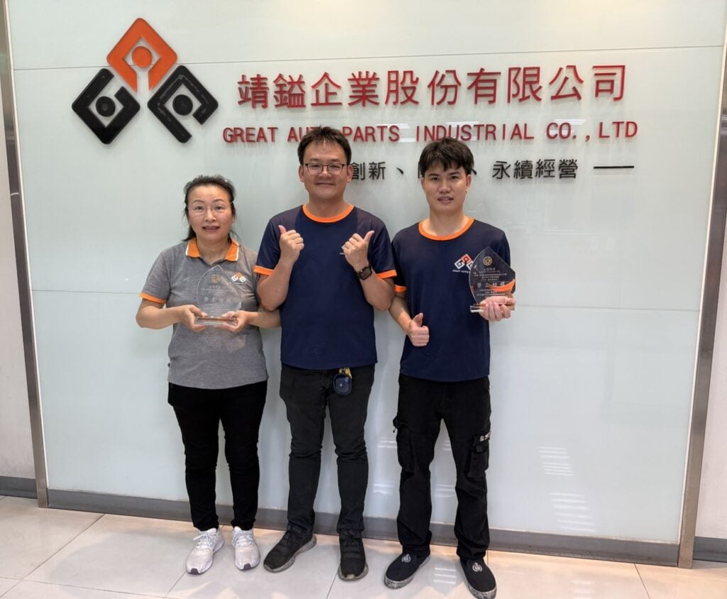 Great Auto Parts Chairman posing with model workers Ms. Liao and Mr. Nguyen at the company office.